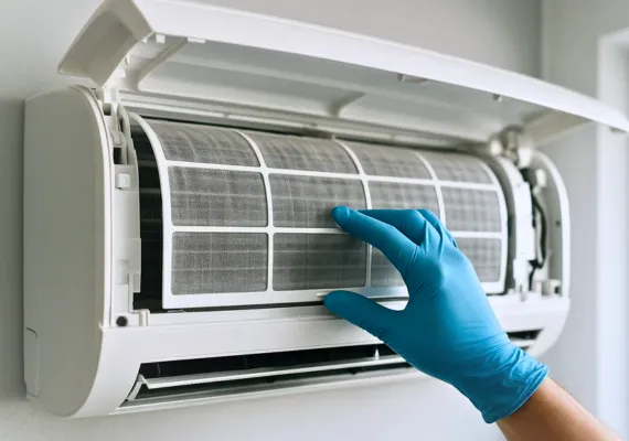 Technician replacing air conditioner filter during maintenance