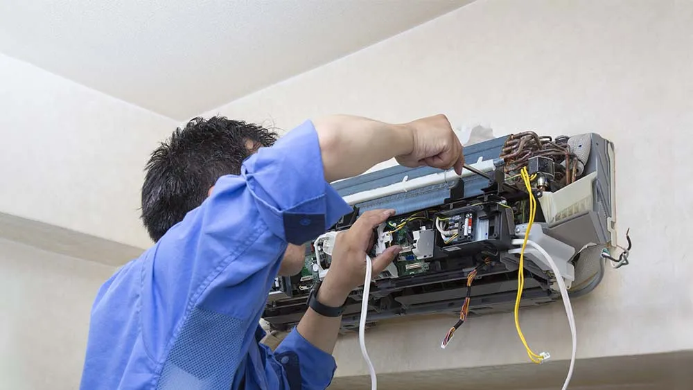 AC repair technician testing air conditioner after service