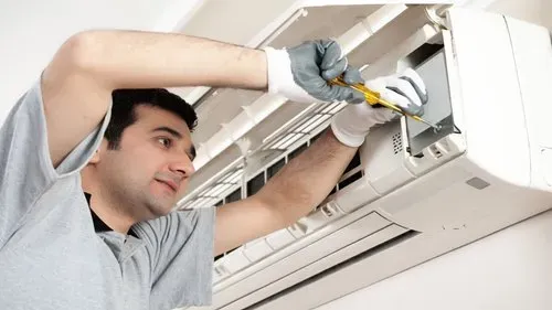 Technician inspecting air conditioning system components