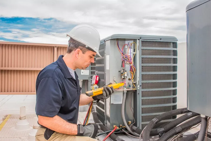 Expert fixing broken air conditioner with precision tools